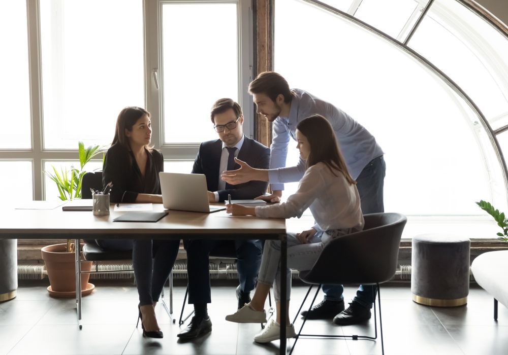 Employees gathered in a meeting around the table